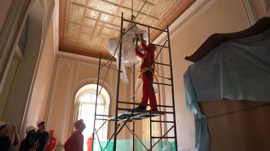 Operários retiram lustres para embalar e repor após o final da reforma do Palácio Antônio Lemos.